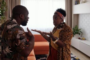 A couple argues with each other, looking visibly shocked and upset.