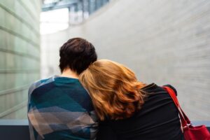 woman sitting with her head on the man's shoulder