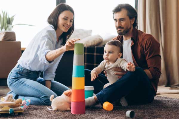 Happy couple with baby playing together at home