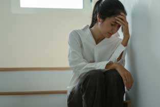 Woman sitting on stairs experiencing anxiety in the Bay Area