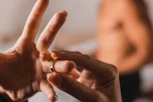 Hand removing wedding ring, symbolizing infidelity in Silicon Valley