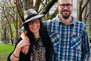 Smiling couple standing together in a Portland park, representing couples therapy support