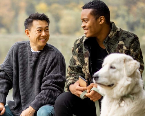 Same-sex couple enjoying time outdoors with their dog